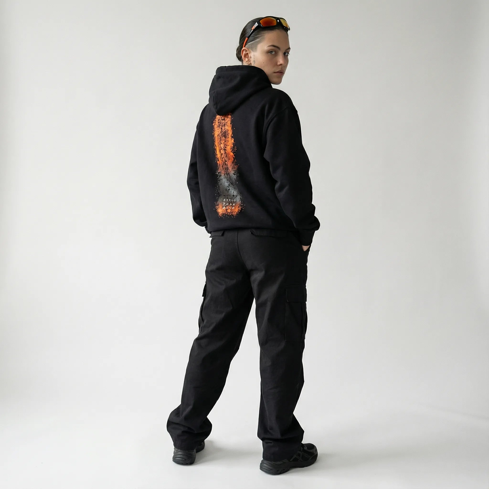 Person wearing a black JAYTEE zoodie with a unique design on the back against a white background