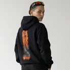 Person wearing a black JAYTEE hoodie with a unique design on the back against a white background