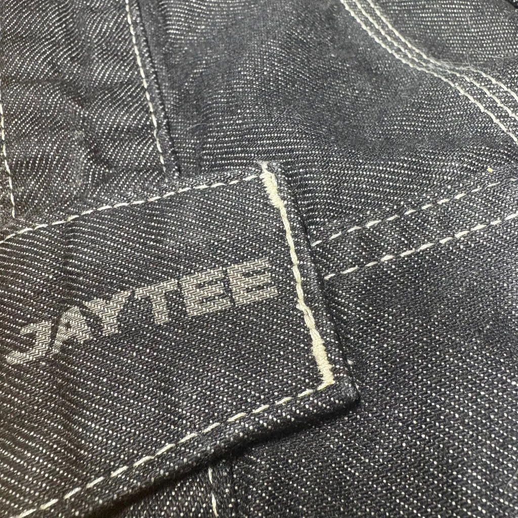 Close-up of a denim fabric with 'JAYTEE' branding.