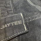 Close-up of a denim fabric with 'JAYTEE' branding.
