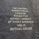 Text on denim fabric stating 'I'm tough, ambitious. I know exactly what I want. If that makes me a bitch, okay.'